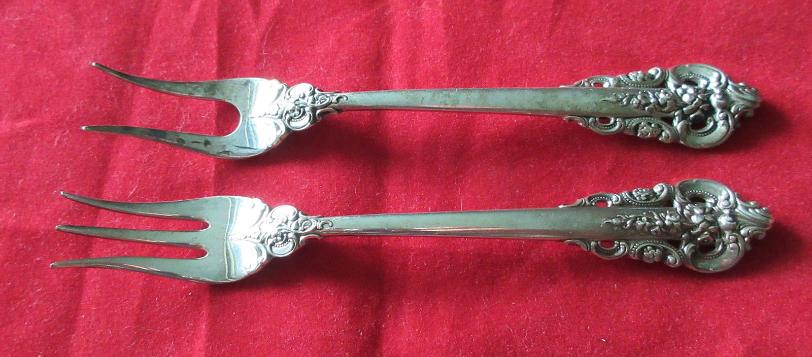 2 Elegant Grande Baroque sterling flatware olive forks: 2 Elegant Grande Baroque sterling flatware olive forks. In good original as found condition with great quality and detail. Need polished Measures 5 1/2 inches. 50 grams