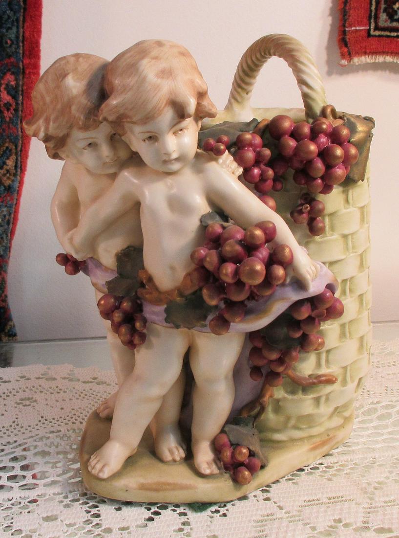 Marvelous Amphora cupid figural vase: Marvelous Amphora cupid figural vase. Measures 8 inches tall. In good original as found condition. Beautiful colors with great quality and detail.