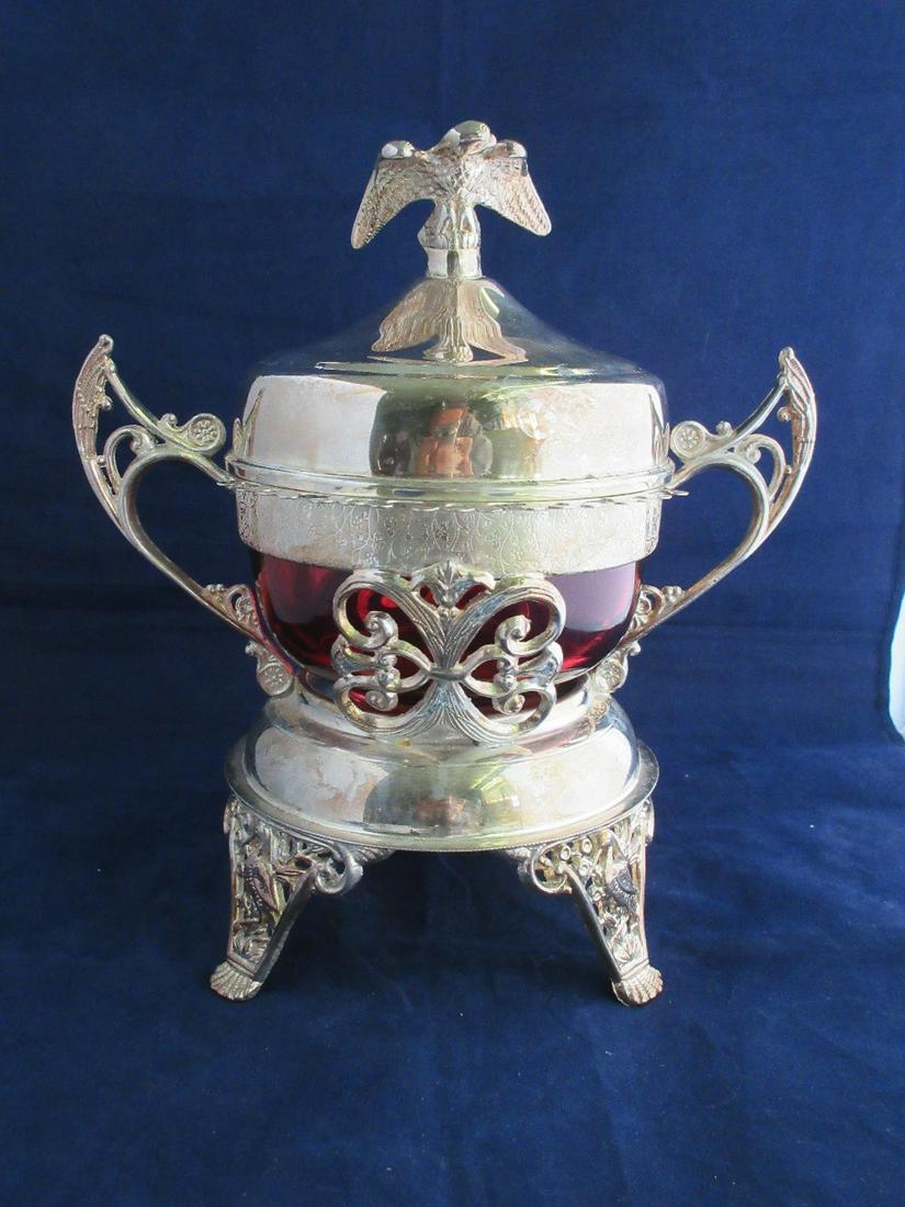 Fabulous Victorian fancy art glass spoon holder: Fabulous Victorian fancy art glass spoon holder. Cranberry insert in fancy silver plate frame with eagle and stork feet. Holds spoons on outside rim. Measures 9 inches tall and 8 ½ inches wide.