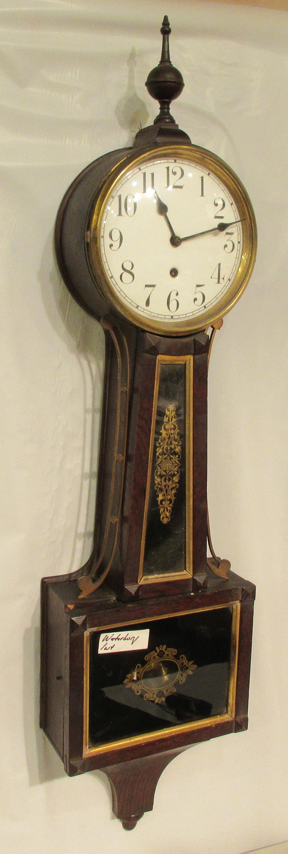 Waterbury Banjo clock. Porcelain dial: Waterbury Banjo clock. Porcelain dial. Circa 1900. Original finish. Original beveled glass in door and waist. Good back label. Good porcelain beat scale