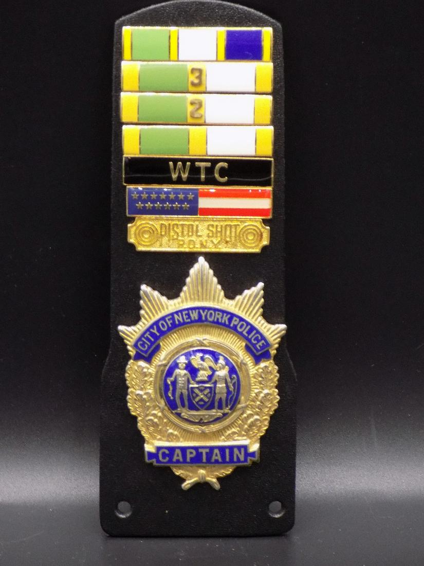 Incredible World Trade Center Captains Badge: Incredible World Trade Center Captains Badge. City of New York Police Captain. With service medals. In very good original as found condition. Great quality and detail. Mounted on hard rubber that meas