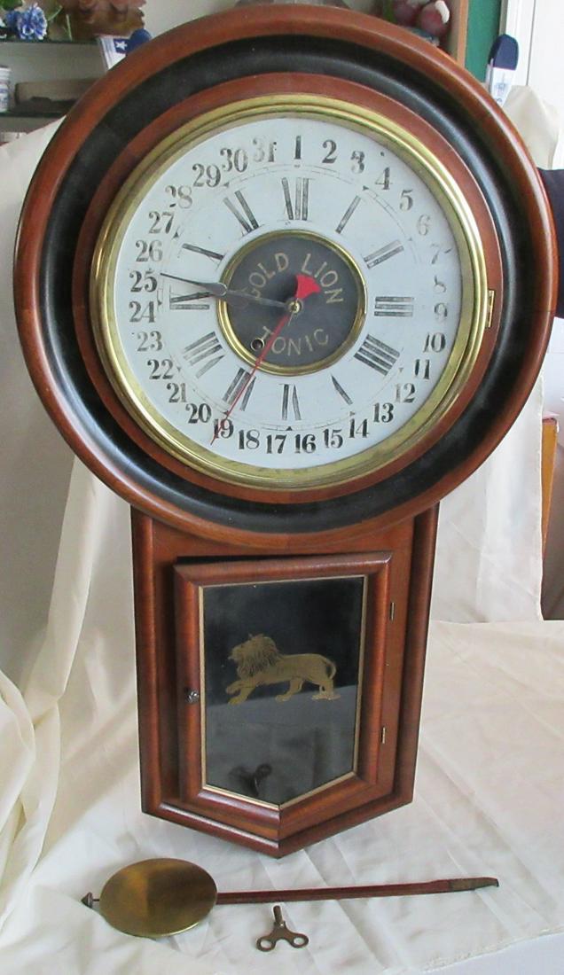 Magnificent Gold Lion Tonic advertising long drop: Magnificent Gold Lion Tonic advertising long drop regulator clock with calendar dial. New Haven clock company label on back as shown in photo. In good original as found condition. Original varnish. Ru
