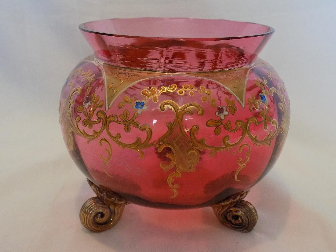 Pretty hand decorated Moser art glass footed bowl: Pretty hand decorated Moser art glass footed bowl. Beautiful cranberry glass with hand enameled and gold decoration. No markings. No condition problems. 4 7/8” tall x 5 ½” wide