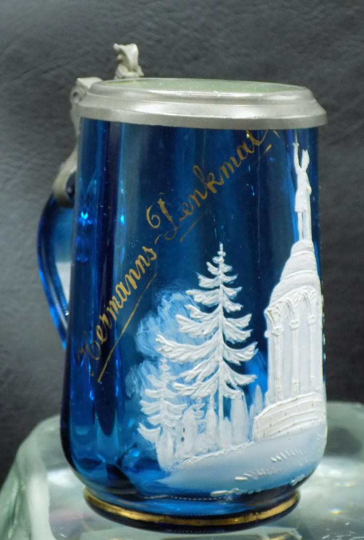 Pretty hand decorated antique art glass stein: Pretty hand decorated antique art glass stein. Blue art glass with pewter and clear glass top. Hand enamel decorated. Gold writing on side. Great quality and detail. 4 1/8 inches tall