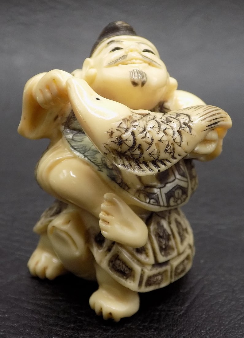 Vintage hand carved Oriental Netsuke figure of man with fish sitting on (1 of 8)