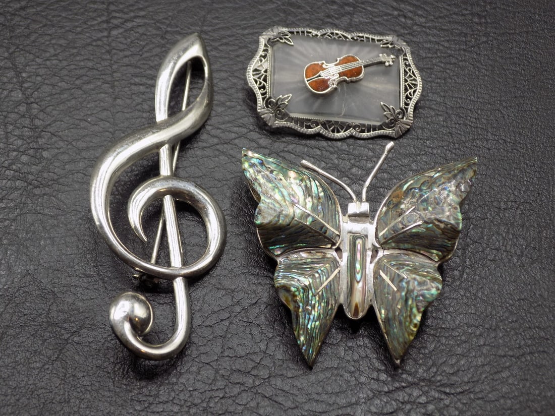 Three wonderful vintage sterling silver jewelry: Three wonderful vintage sterling silver jewelry. All pins. Butterfly marked Taxco. Please see photos for markings. Filigree pin with violin. Mother of Pearl Inlaid butterfly 1 ½ tall x 1 5/8 wide