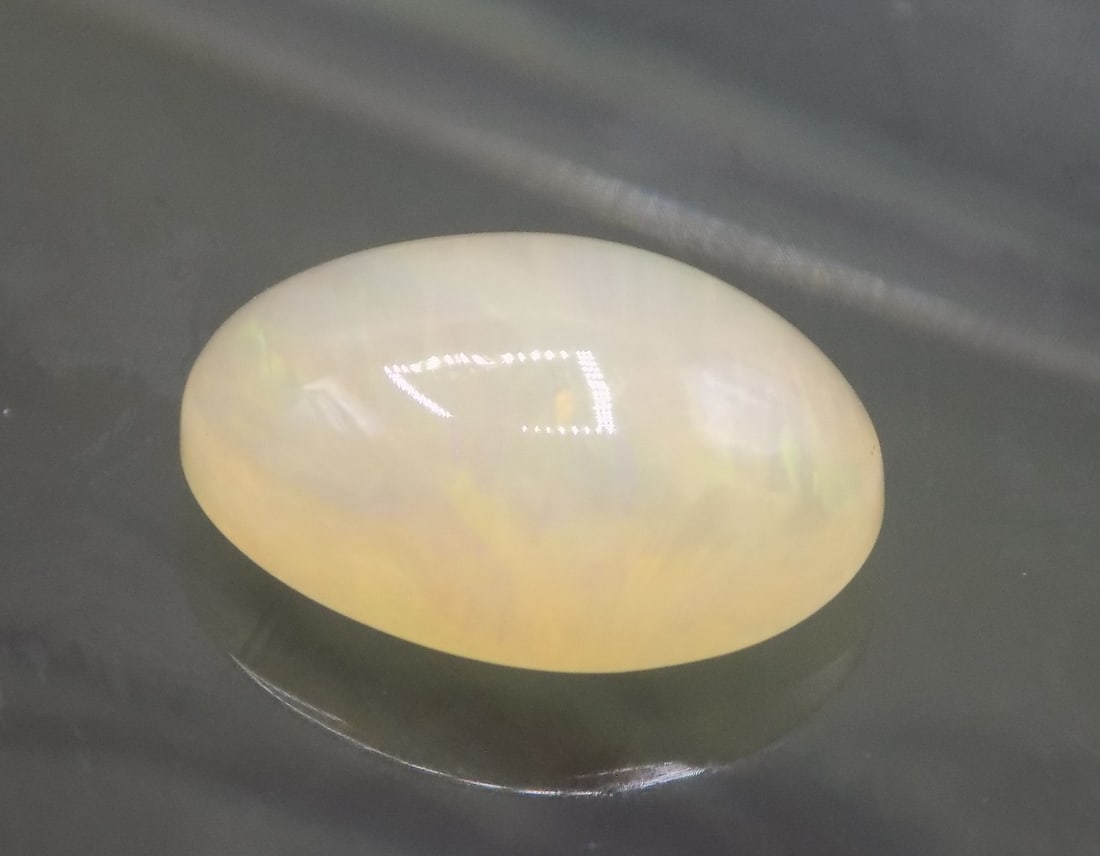 Beautiful 2.06 ct Ethiopia opal gemstone: Beautiful 2.06 ct Ethiopia opal gemstone. Beautiful colors. Has a small chip on edge as shown in photo. Please see photos
