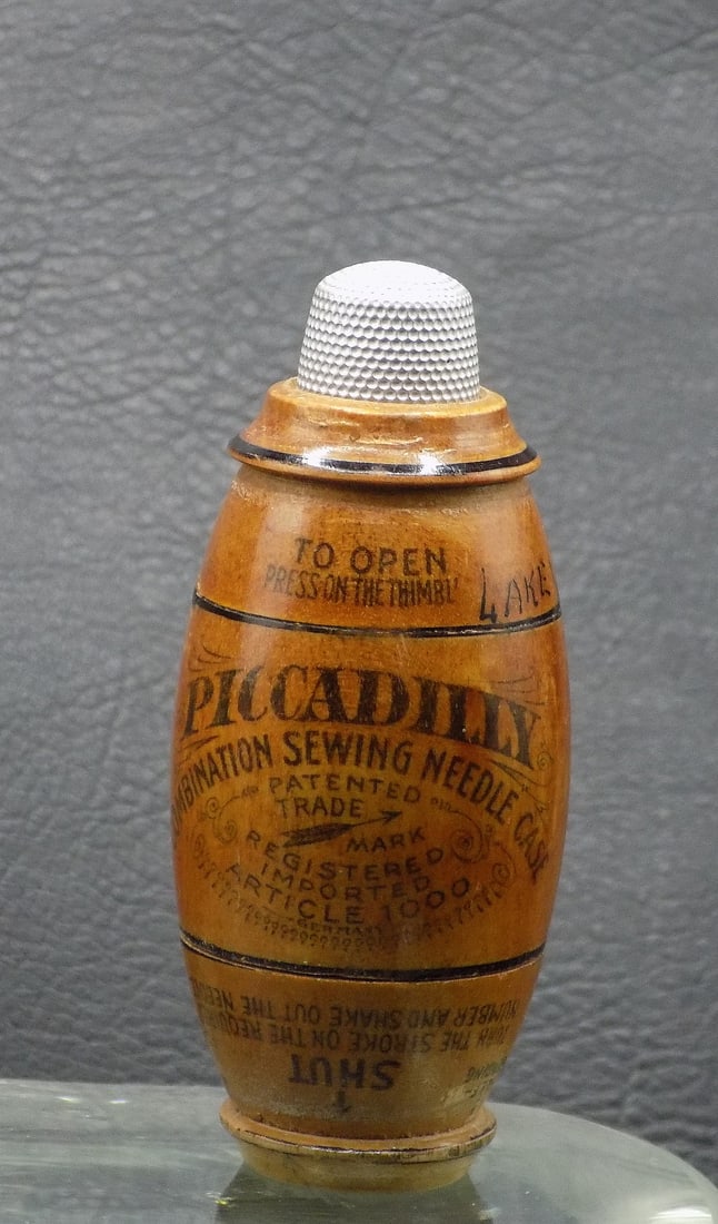 Antique Piccadilly Treen combination sewing needle case: Antique Piccadilly Treen combination sewing needle case. Made in Germany early 1900s. Holds needle, thread and thimble as shown in photo. In very good original as found condition. 3 1/8 inches tall