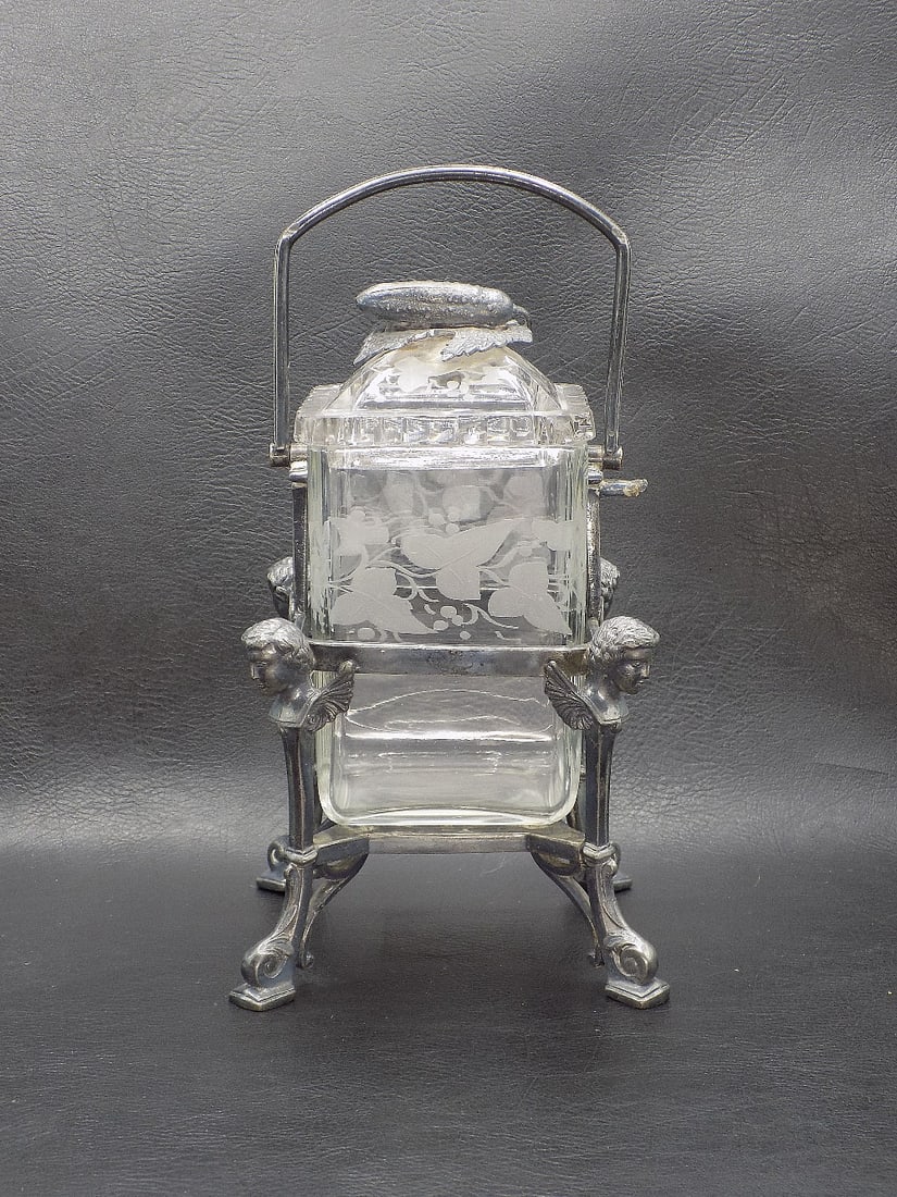 Ornate Victorian Reed and Barton pickle castor with angles: Ornate Victorian Reed and Barton pickle castor with angles. Intaglio cut leaf design on jar. Pickle on lid. Frame marked Reed and Barton. Silverplate with angels and scrolled feet on frame. In very go