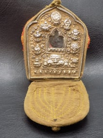 Vintage Tibetan embossed silver ghau religious box with cloth cover.