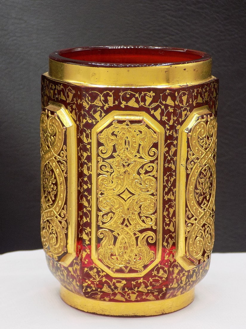 Elaborate decorated Moser art glass glass: Elaborate decorated Moser art glass glass. Heavy gold decoration over red glass. Three dimensional panels. Beautiful colors. Great quality and detail. In very good original as found condition. 3 7/8 i