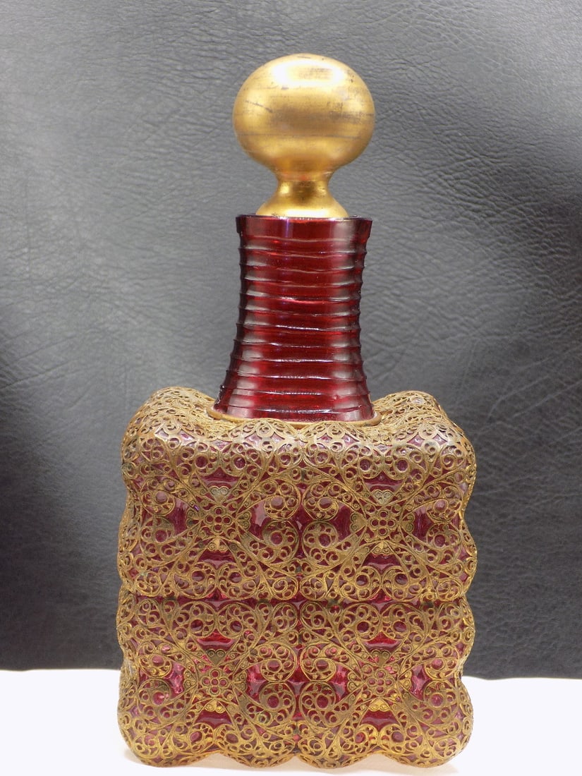 Fancy antique art glass perfume bottle: Fancy antique art glass perfume bottle. Elaborate metal overlay over cranberry glass. Beautiful colors. Great quality and detail. In very good original as found condition. Light wear to gold on top of