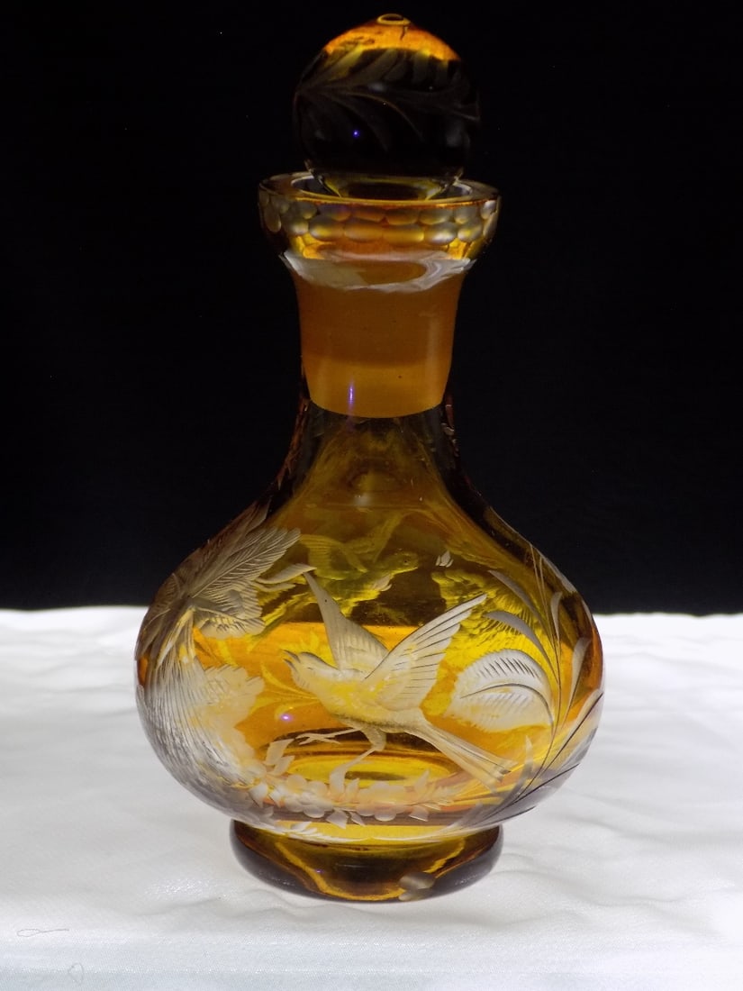 Beautiful antique art glass perfume bottle: Beautiful antique art glass perfume bottle. Amber glass cut to clear decoration with bird and flowers. Beautiful colors. Great quality and detail. Has a very hard to see fleabite chip on top rim as sh
