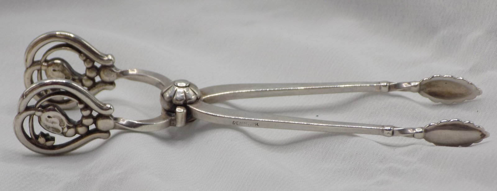 Ornate Georg Jensen sterling silver sugar tong.: Ornate Georg Jensen sterling silver sugar tong. Marked as shown in photo. In very good original as found condition. Great quality and detail. 4 inches long. 23 grams.