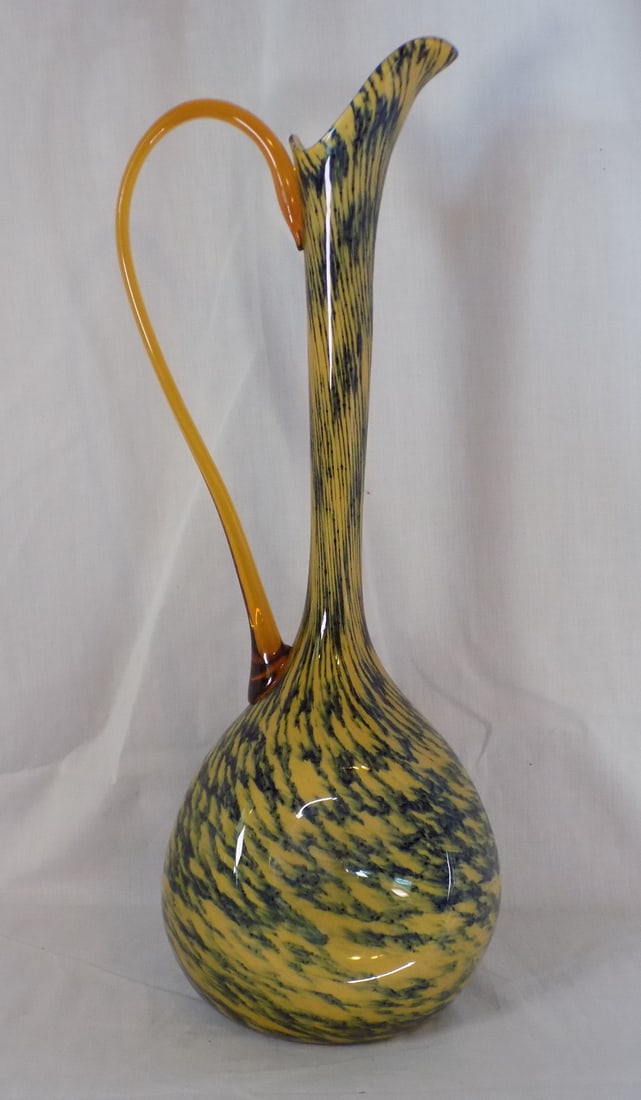 Very tall midcentury modern art glass pitcher.: Very tall midcentury modern art glass pitcher. Beautiful colors. Amber applied handle. 18 ¾ inches tall x 6 ½ inches wide. White spots are camera flash.