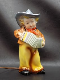 Vintage cowboy playing accordion lamp.
