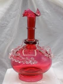 Beautiful vintage cranberry art glass vase with clear applied leaves.