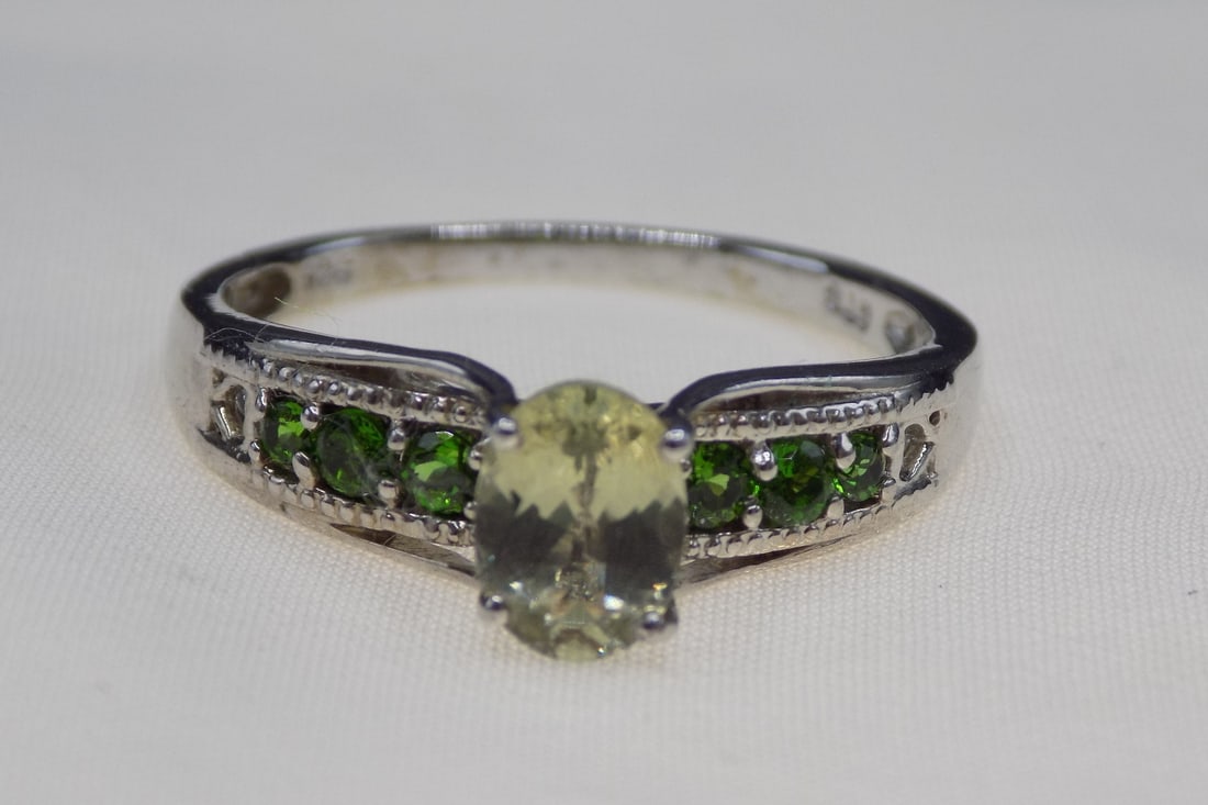 Beautiful 1 cwt topaz and emerald sterling silver ring: Beautiful 1 cwt topaz and emerald sterling silver ring. Lab created emeralds. Size 9. For in house shipping, please call Mike at Thriftiques 319-321-0613