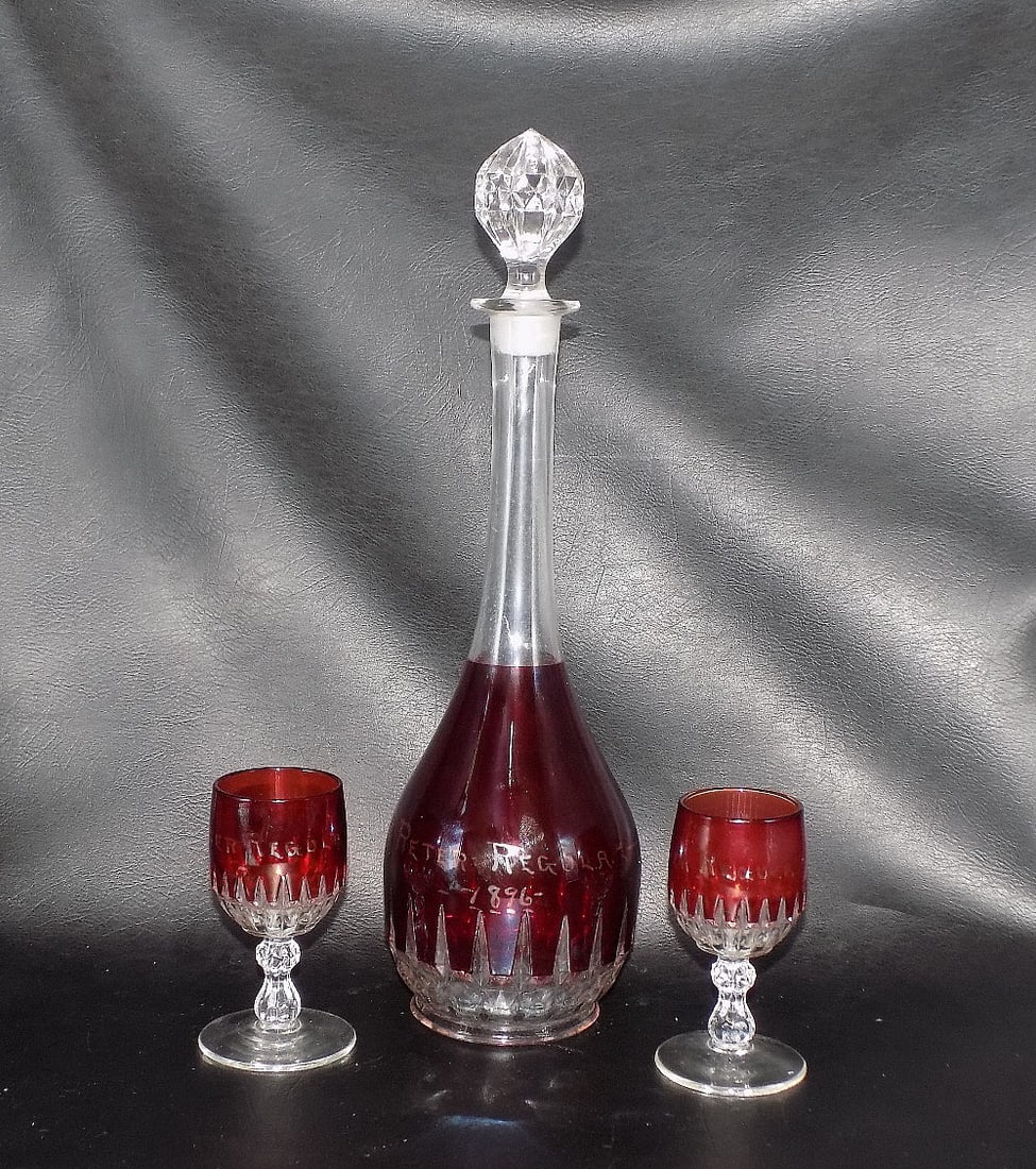 1896 Bohemian art glass liquor set.: 1896 Bohemian art glass liquor set. Red cut to clear glass design. Beautiful colors. Name with date on side as shown in photo. In very good original as found condition. Great quality and detail.