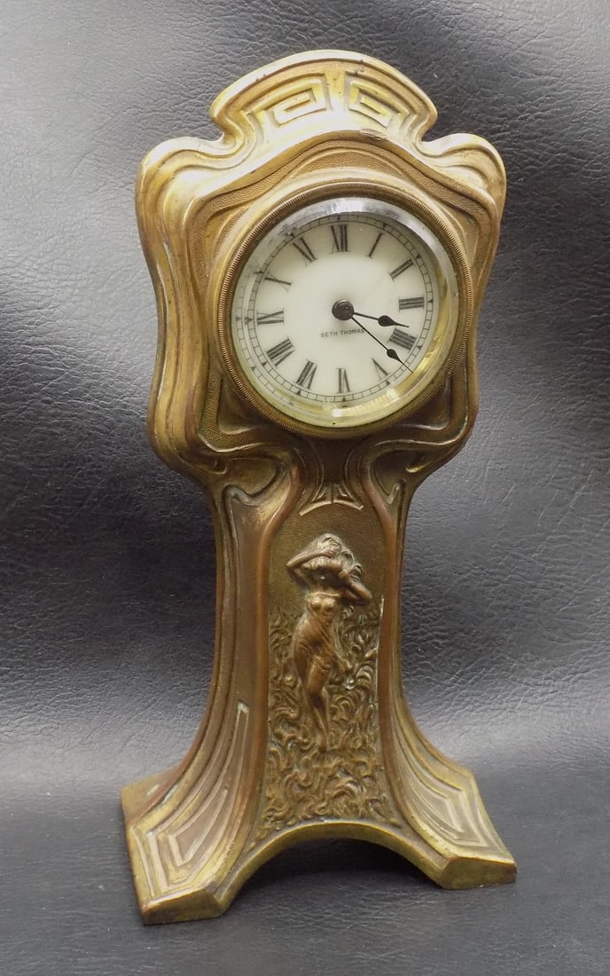 Antique bronze Seth Thomas clock with nude female: Antique bronze Seth Thomas clock with nude female. Marked on face with beveled glass dial front. Measures 8 inches tall. Running part time. Beautiful colors. In very good original as found condition.