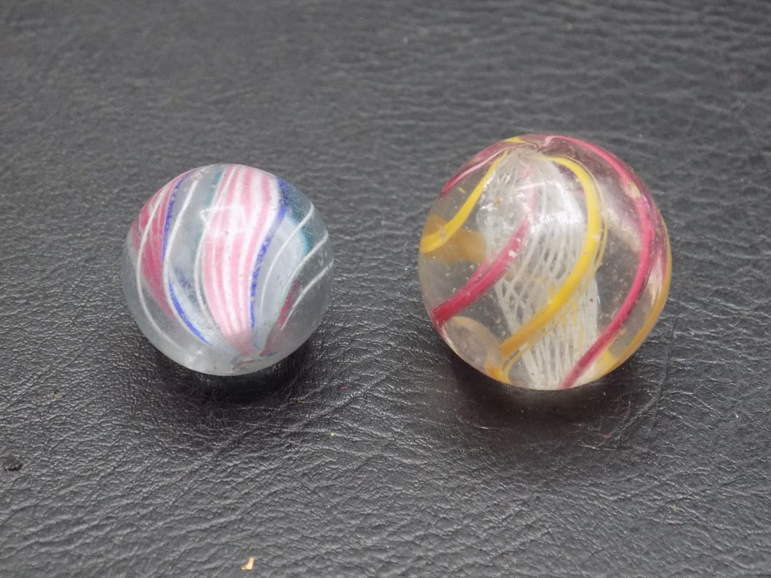 Two antique German art glass swirl marbles: Two antique German art glass swirl marbles. Please see photos for condition. Beautiful colors. Great quality and detail. Largest marble 7/8 inches. For in house shipping, please call Mike at Thriftiqu