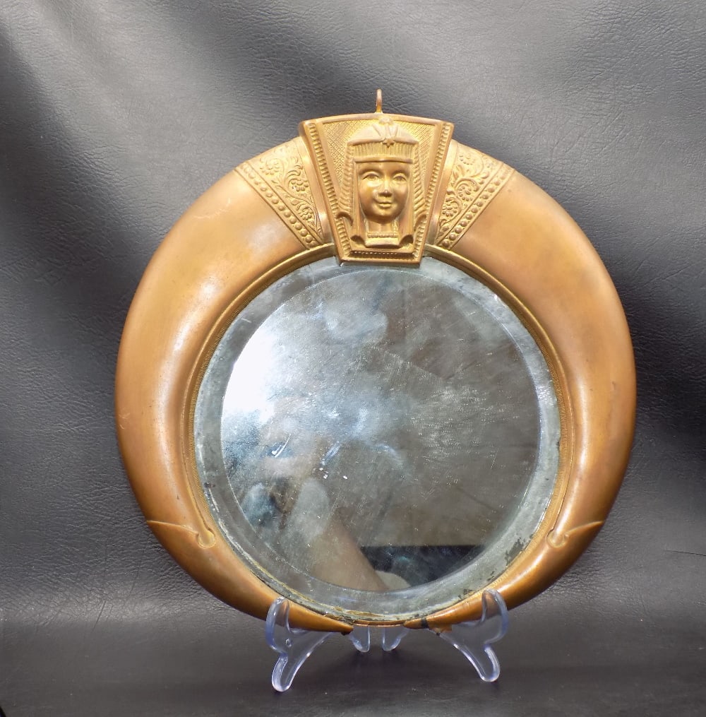 Antique mirror with Egyptian motif: Antique mirror with Egyptian motif. Solder on mirror to hold to frame is undone and mirror is loose. Original patina. Great quality and detail. 9 ½ tall x 9 ½ wide at center. Approximate