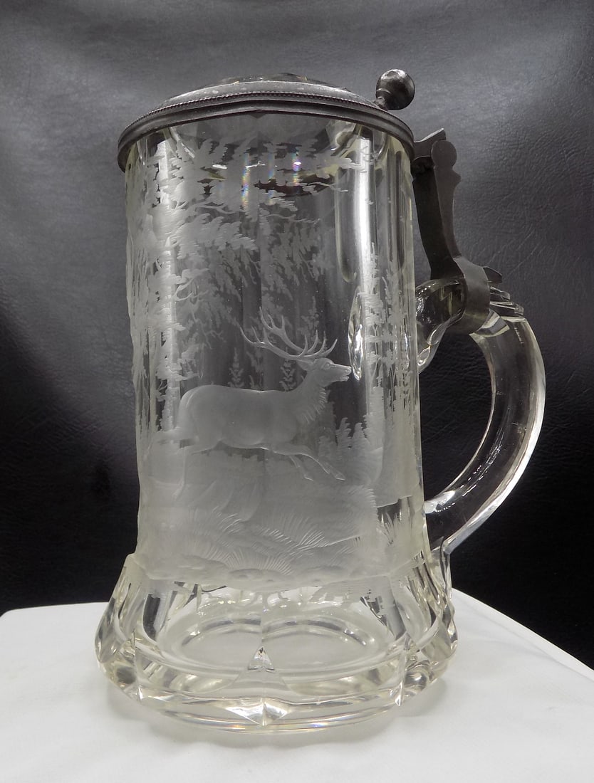 Antique German glass beer stein with etched deer and forest scene: Antique German glass beer stein with etched deer and forest scene. Pewter and cut glass lid. In very good original as found condition. Great quality and detail. 7 58 inches tall x 4 1/8 wide at base.