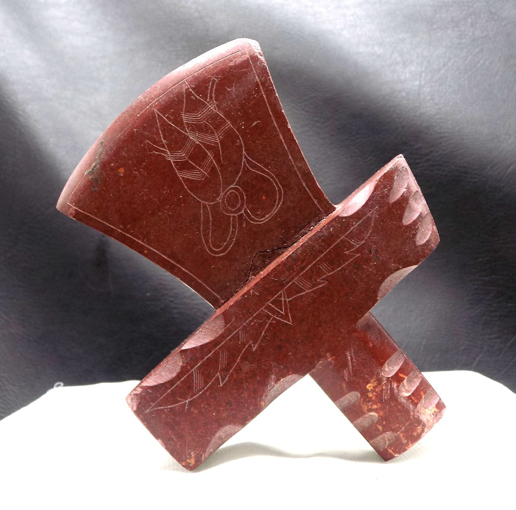Native American Indian engraved catlinite pipe in the shape of axe head: Native American Indian engraved catlinite pipe in the shape of axe head. Hairline crack shows break and reglued as shown in photo. Great quality and detail. 4 ½ inches x 3 ¾ inches. For