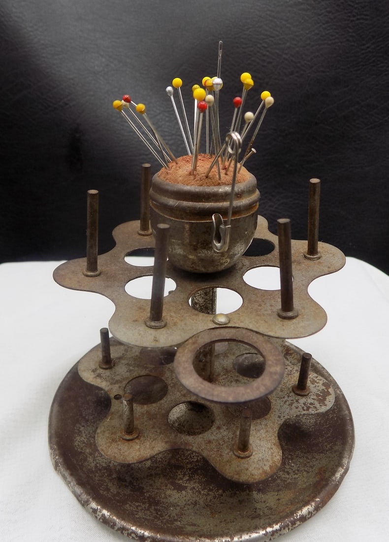 Antique sewing stand pin cushion and thread holder: Antique sewing stand pin cushion and thread holder. Shows age and wear.. Great quality and detail. 3 5/8 tall x 3 5/8 wide at base. For in house shipping, please call Mike at Thriftiques 319-321-0613