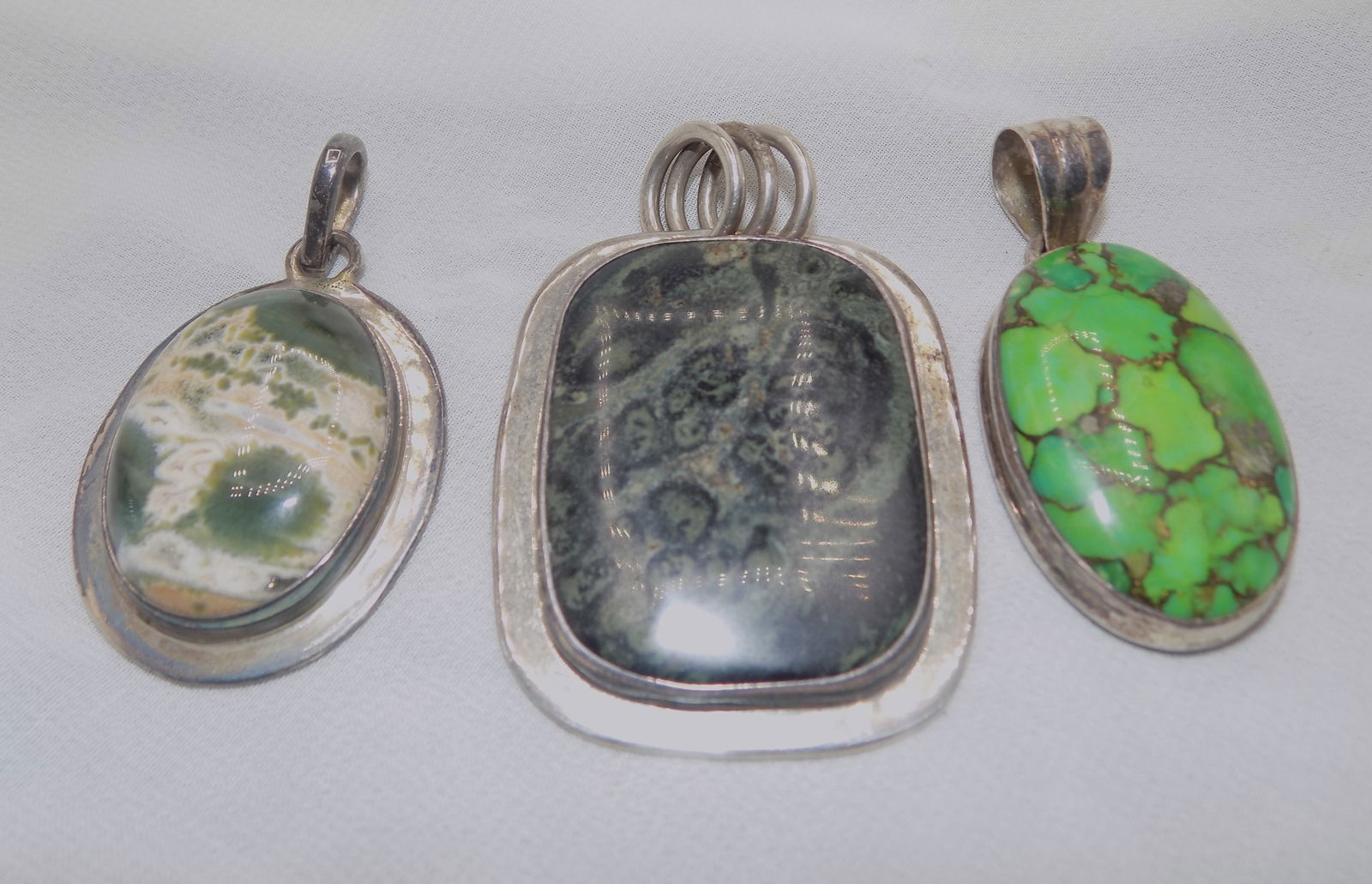 Three vintage marked sterling pendants: Three vintage marked sterling pendants. Moss agate, Kabamba jasper, and green turquoise 2 inches tall. Beautiful colors. In very good original as found condition. Great quality and detail. White lines