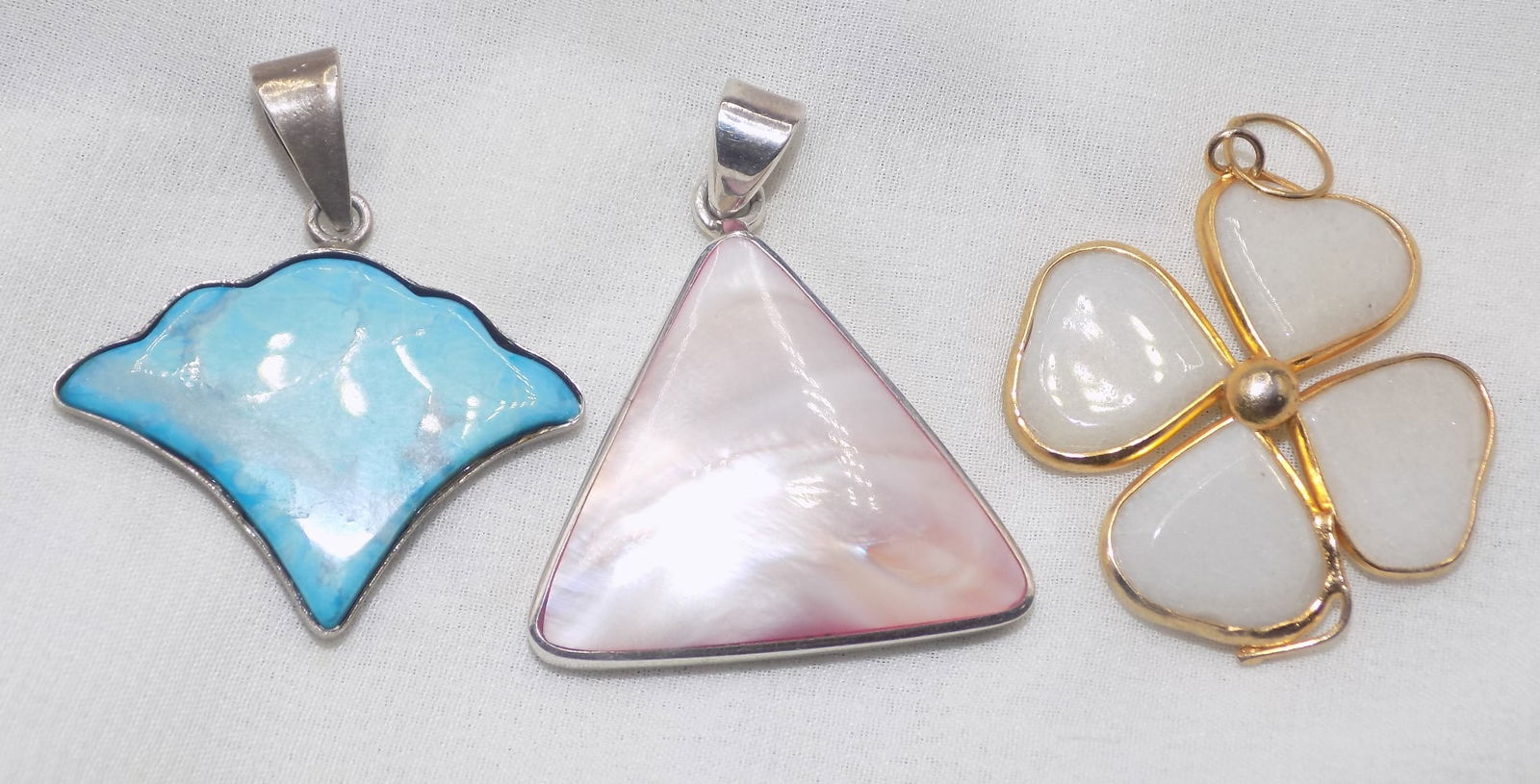 Three vintage marked sterling pendants: Three vintage marked sterling pendants. Lirimar gemstone. Pink mother of pearl shell 1 ½ triangle shaped and mother of pearl in clover shape. Beautiful colors. In very good original as found co