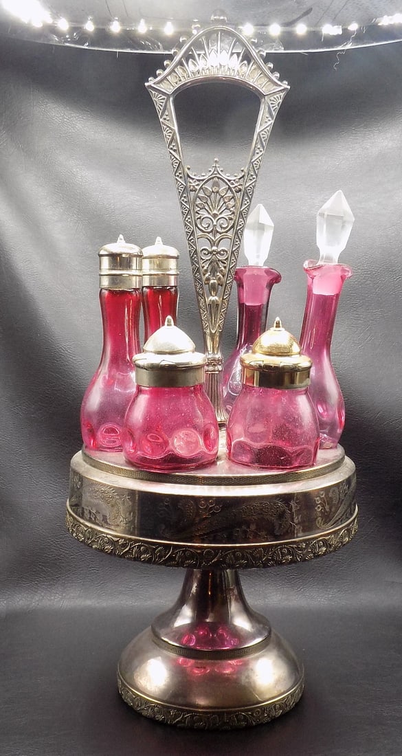 Fancy Victorian cranberry glass cruet set: Fancy Victorian cranberry glass cruet set with silver plated caddy. Thumb print pattern.