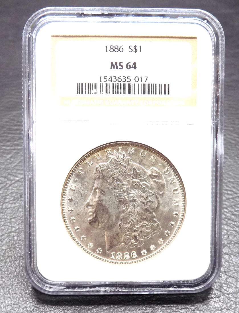 1886 Uncirculated MS 64 Morgan silver dollar graded by NGC.: 1886 Uncirculated MS 64 Morgan silver dollar graded by NGC. Please see photos. For in house shipping. Please call Mike at Thriftiques 319-321-0613