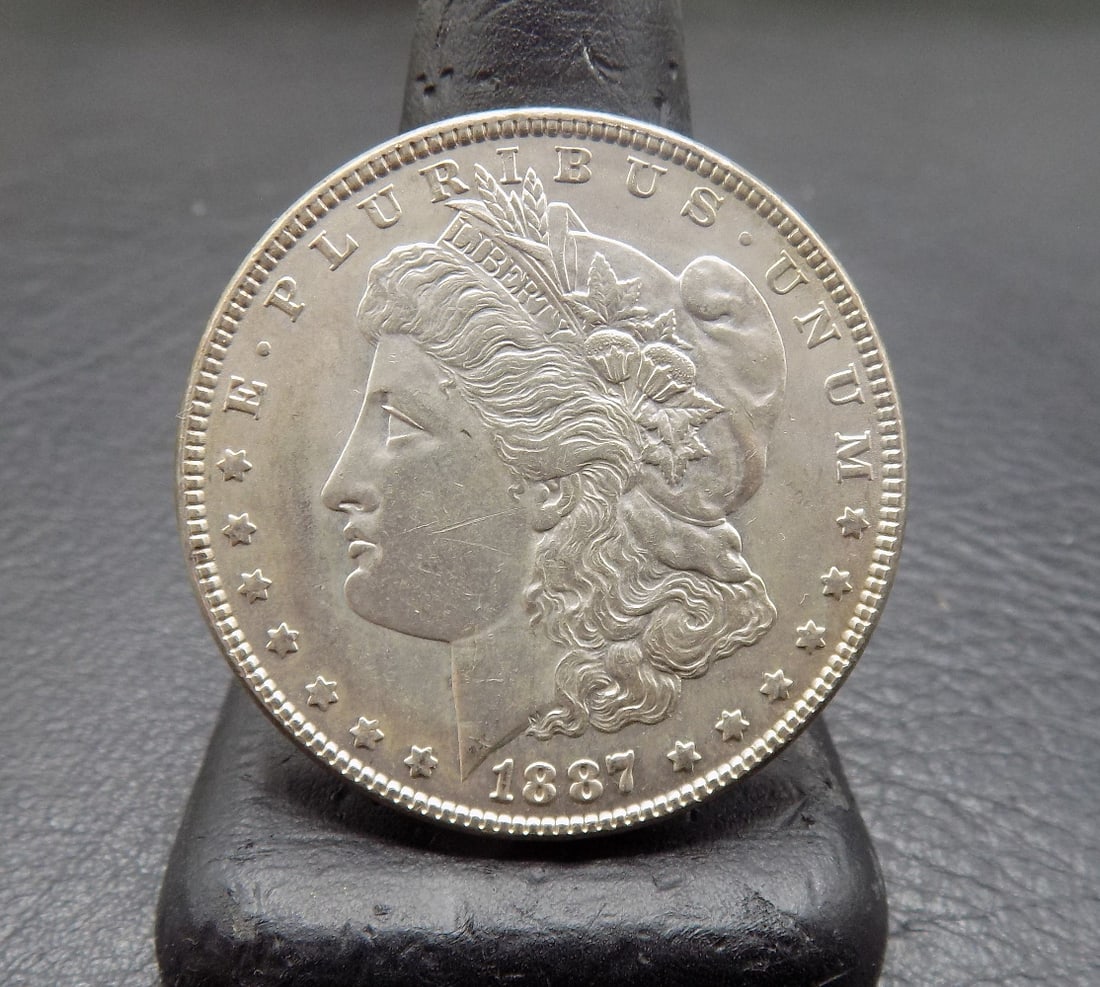 Uncirculated 1887 Morgan silver dollar: Uncirculated 1887 Morgan silver dollar. Please see photos. For in house shipping, please call Mike at Thriftiques 319-321-0613