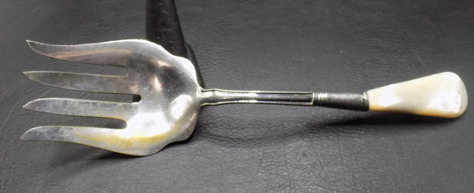 Large sterling silver serving fork with mother of pearl handle: Large sterling silver serving fork with mother of pearl handle. Marked as shown in photo. In very good original as found condition. Great quality and detail. 9 1/8 inches long. For in house shipping, 