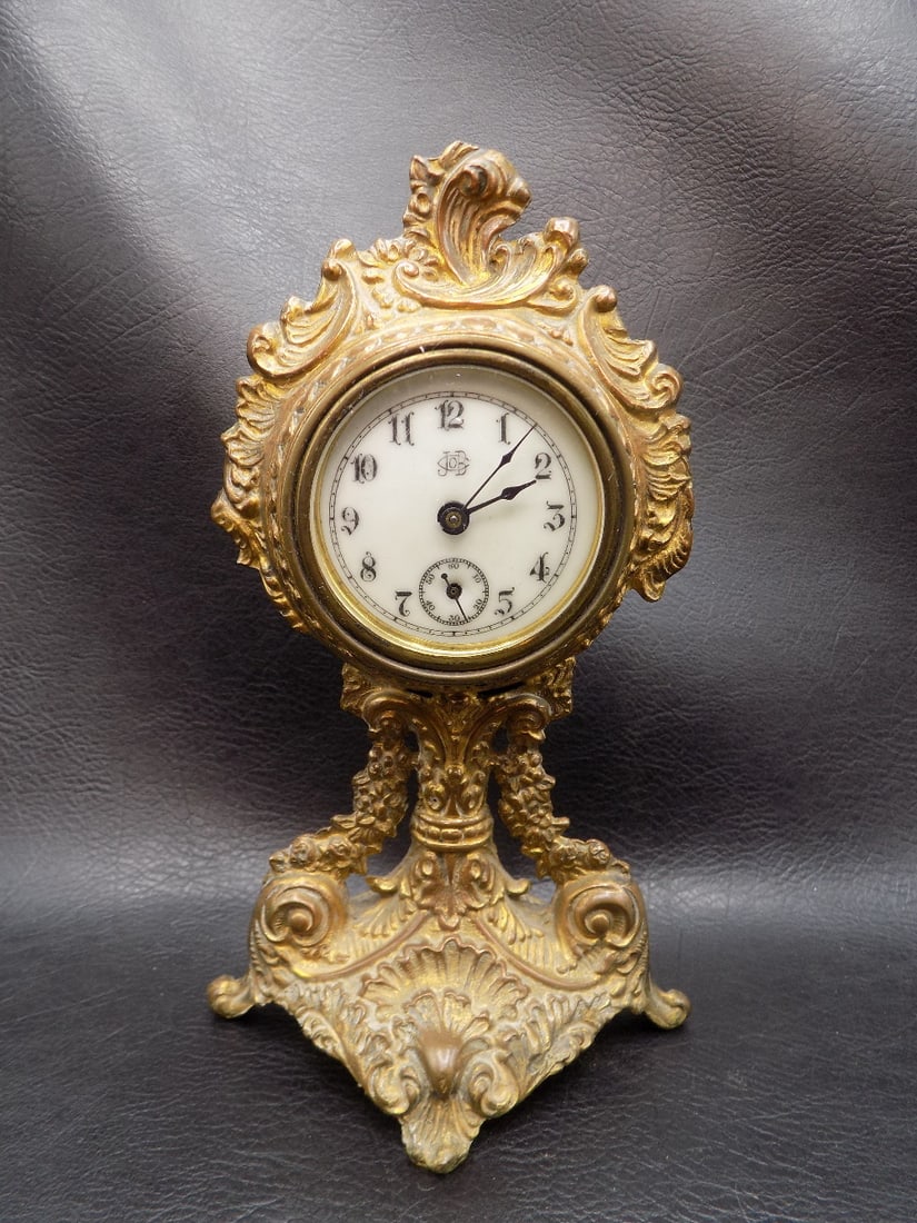 Fancy antique Jennings Bros. clock: Fancy antique Jennings Bros. clock. Wound tight and not running at time of listing. White porcelain dial marked as shown in photo. Appears to be brass or bronze with original patina. 6 7/8 inches tall