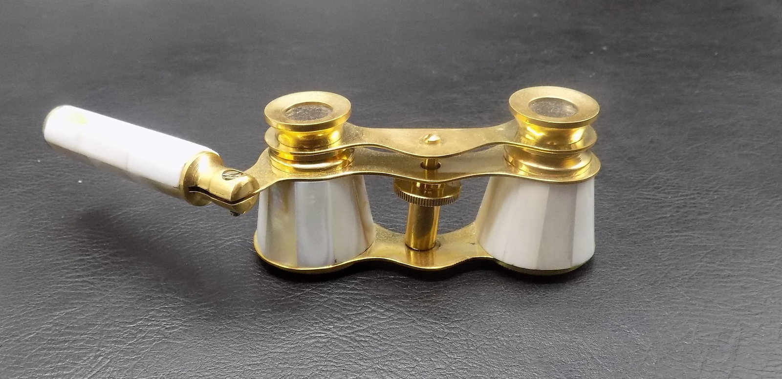 Mother of pearl opera glasses with handle: Mother of pearl opera glasses with handle. Made within the last twenty years. Beautiful colors. In very good original as found condition. 3 3/8 inches wide at front of lenses. Handle is 3 1/8 inches t