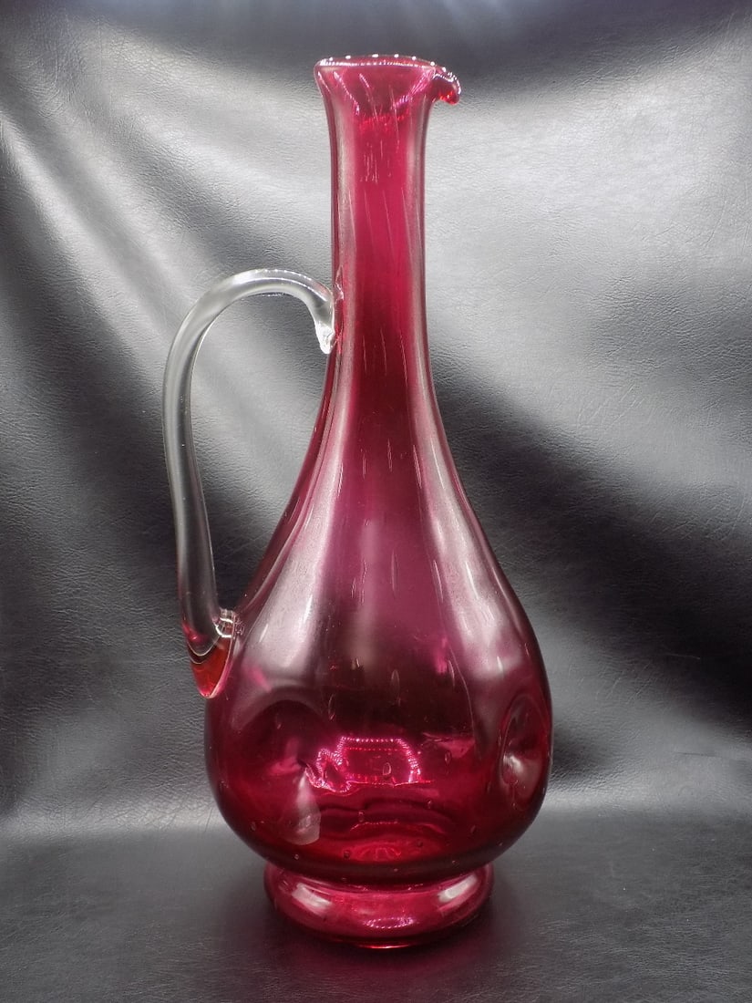Large unusual, decorated midcentury Murano art glass pitcher: Large unusual, decorated midcentury Murano art glass pitcher. Deep cranberry color with dimples in bottom. Elongated internal bubbles at top to small bubbles at bottom. Clear applied handle. Beautiful