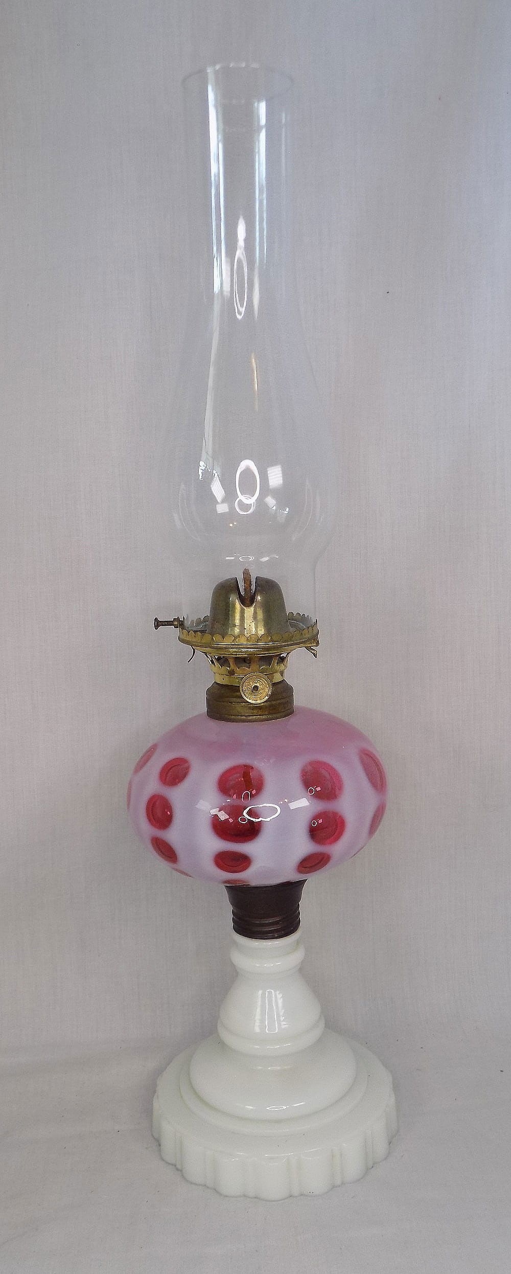 Victorian antique cranberry opalescent coin dot oil lamp: Victorian antique cranberry opalescent coin dot oil lamp. Milk glass base. Beautiful colors. In very good original as found condition. 20 inches tall to top of chimney. Lamp base is 12 inches tall. 2 