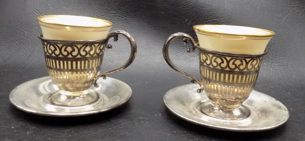 Two antique sterling silver demitasse cups and saucers