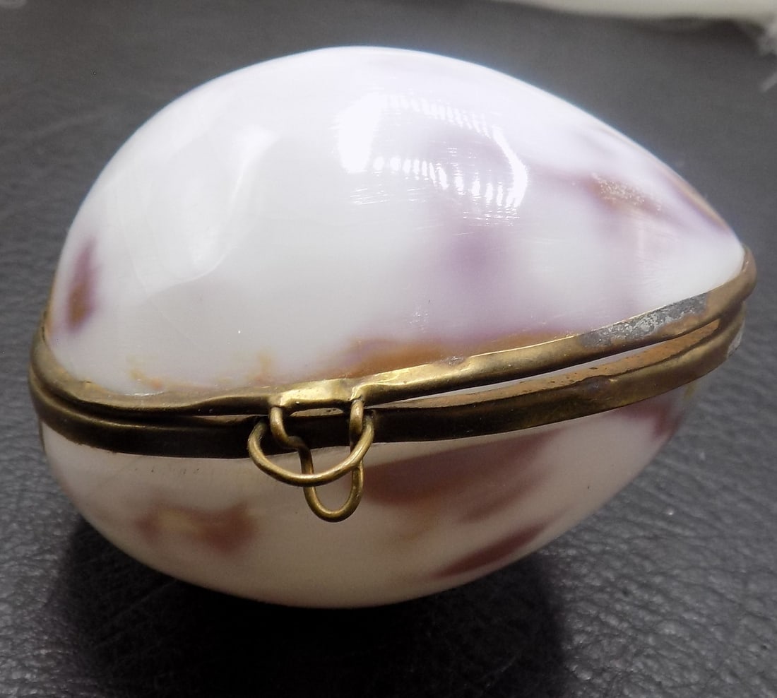 Vintage Cowrie shell jewelry or trinket box with brass trim: Vintage Cowrie shell jewelry or trinket box with brass trim. Beautiful colors. In very good original as found condition. Great quality and detail. 2 5/8 inches x 2 ¼ inches. 1.2 ounces. For in ho