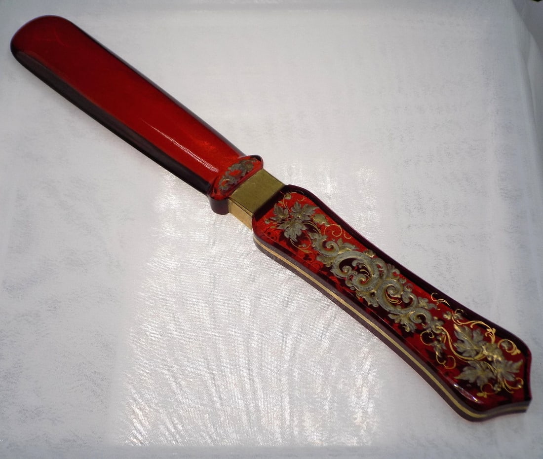 Fancy vintage deep red art glass knife rest: Fancy vintage deep red art glass knife rest. Elaborate gold decoration. Beautiful colors. In very good original as found condition. Great quality and detail. 8 ½ inches long. 4 ounces. For in hou
