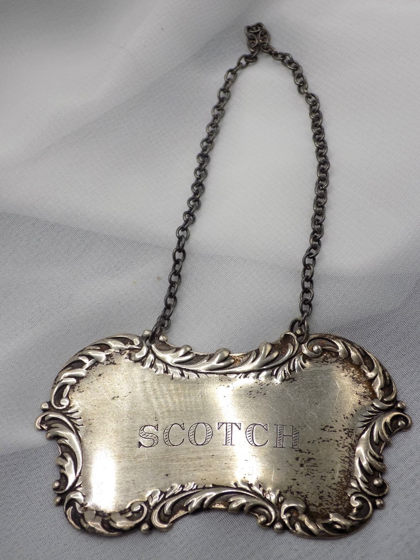 Vintage sterling silver scotch liquor bottle label: Vintage sterling silver scotch liquor bottle label. Marked as shown in photo. In very good original as found condition. Great quality and detail. 2 ¾ inches x 1 ½ does not include chain. 16 