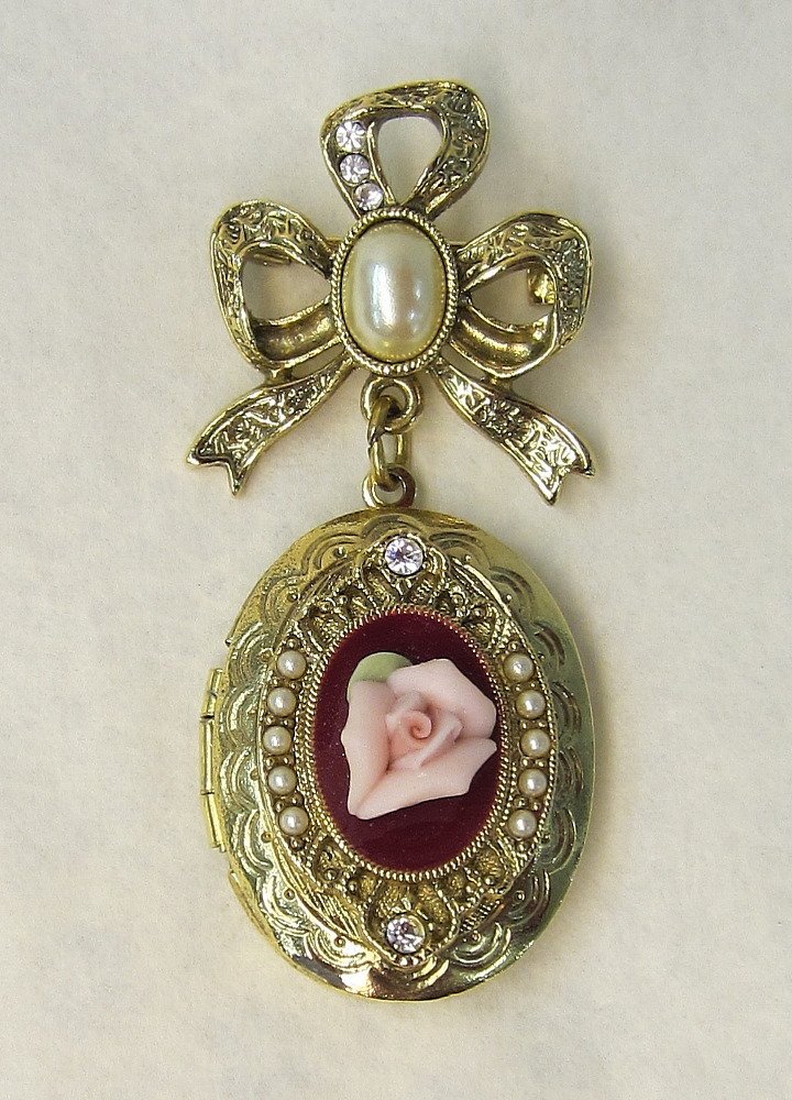 Beautiful Vintage Broach and Locket with Porcelain: Beautiful Vintage Broach and Locket with Porcelain Rose, Rhinestones, and Faux Pearls Decorating it. It measures approximately 2" long.