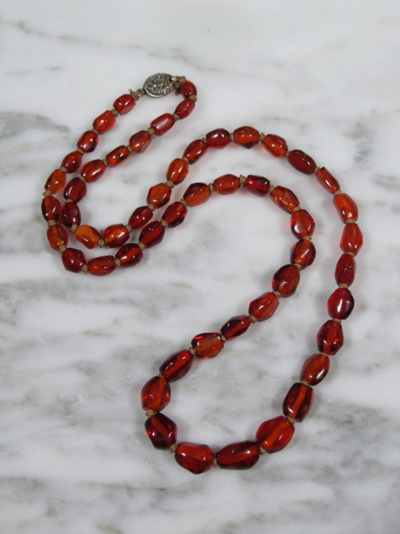 ANTIQUE CHINESE NATURAL BALTIC HONEY AMBER BEAD NECKLAC: ANTIQUE CHINESE NATURAL BALTIC HONEY AMBER BONE BEAD SILVER CLASP NECKLACE. Amber nugget 'bone' beads which graduate from approximately 7.5mm by 6mm, up to 14mm by 10mm. They are hand knotted on tan c