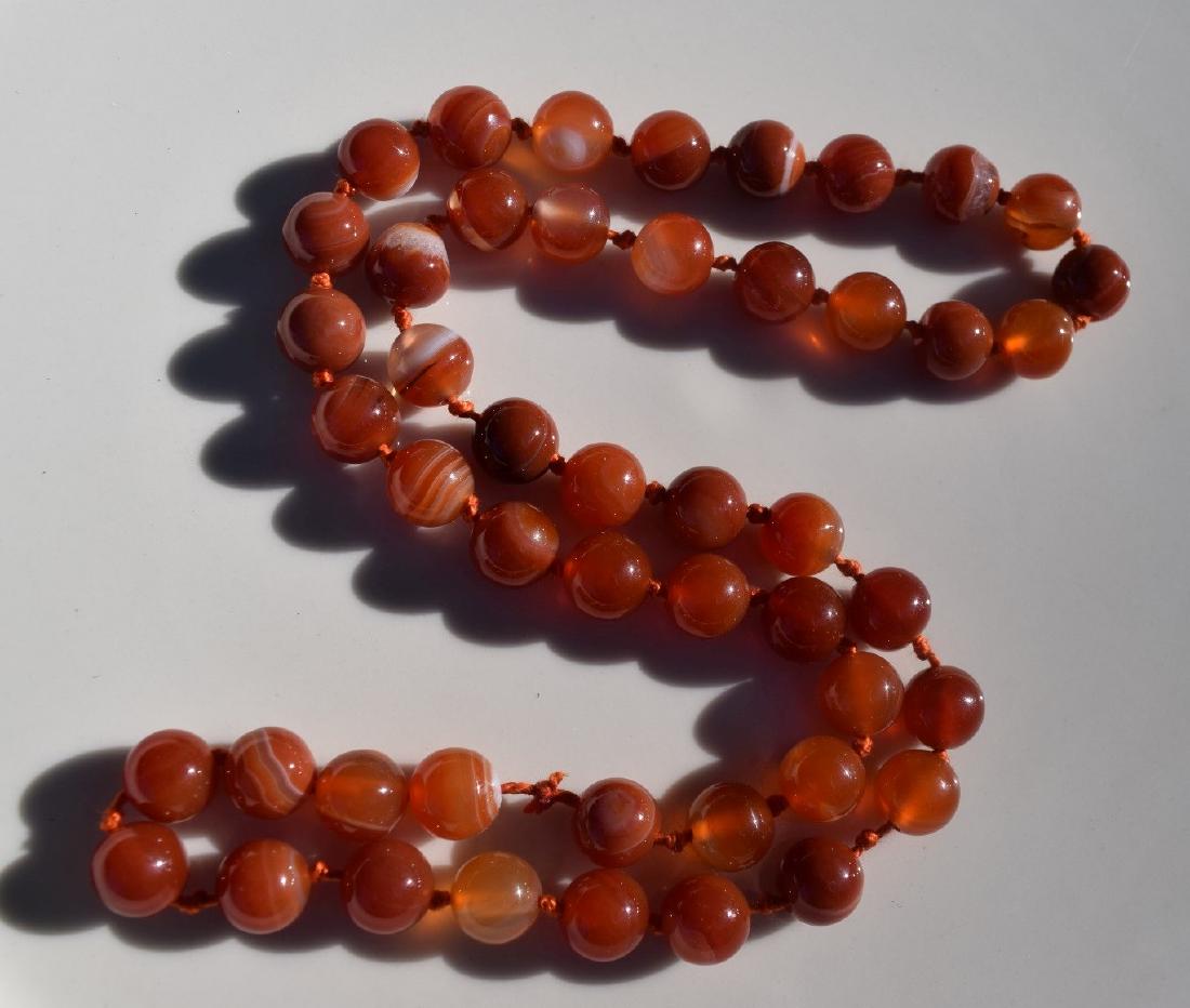 A RED CARNELIAN BEAD NECKLACE: A RED CARNELIAN BEAD NECKLACE, LENGTH: 24", SIZE OF EACH BEAD 10mm