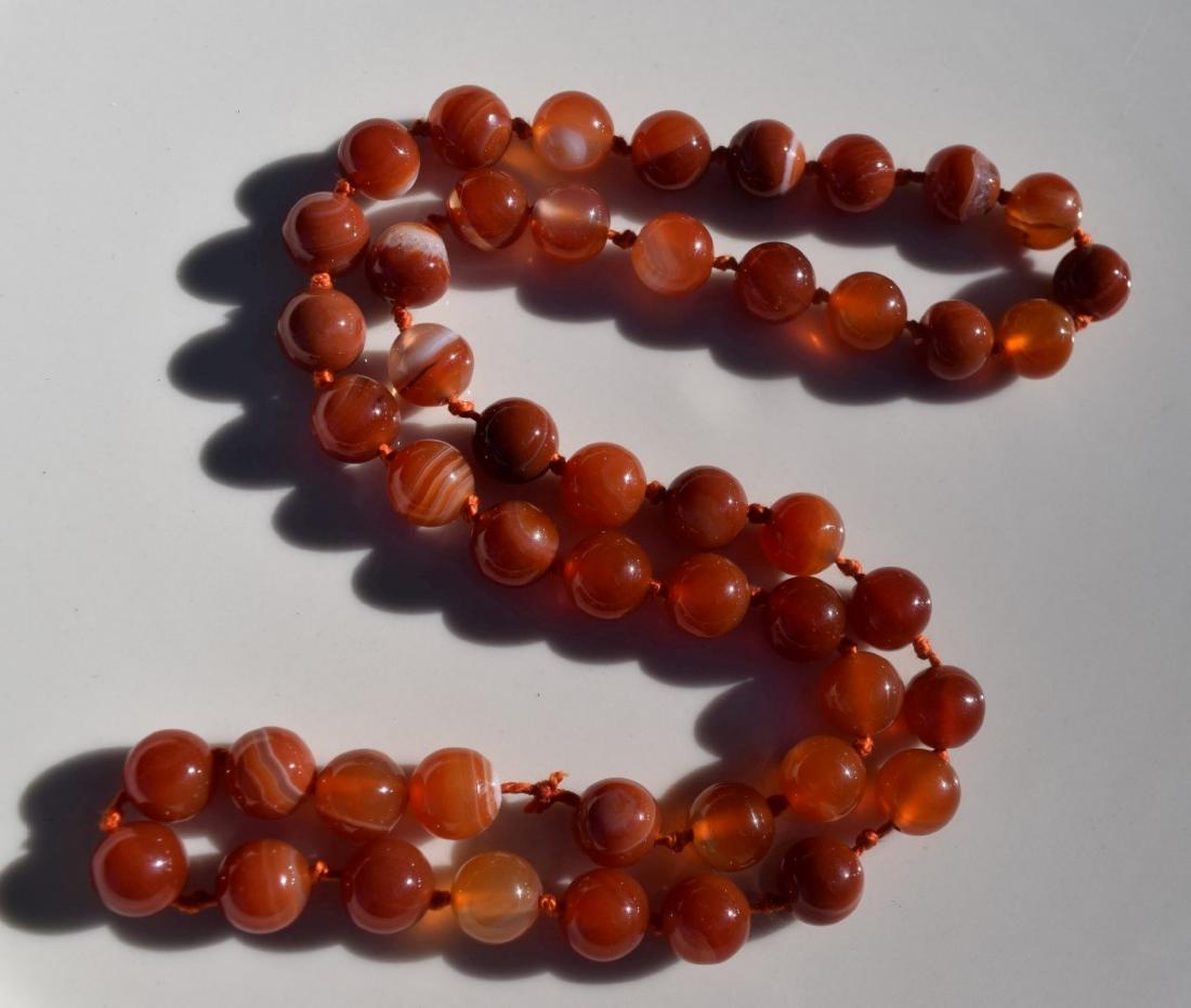 A RED CARNELIAN BEAD NECKLACE: A RED CARNELIAN BEAD NECKLACE, LENGTH: 24", SIZE OF EACH BEAD 10mm