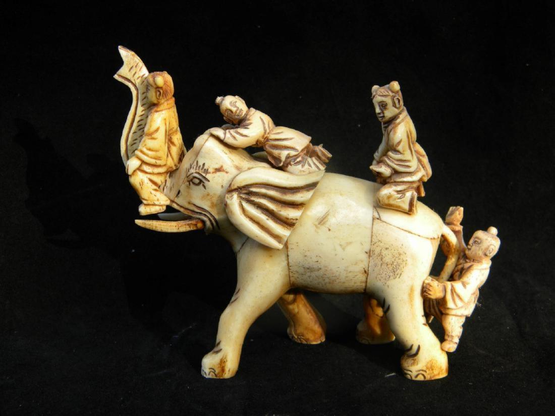 A CARVED CHILDREN ELEPHANT STATUE (1 of 2)