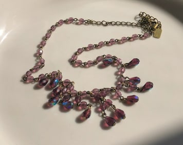 A beautiful vintage necklace with pink beads and an adjustable chain.