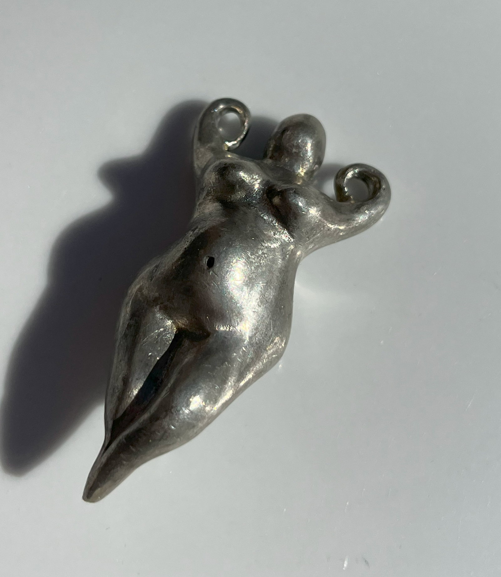 Metal Fat Woman Pendant: A handcrafted metal pendant with a unique design.